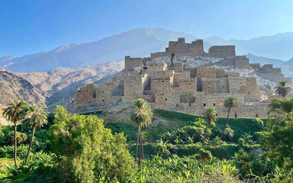 قرية حجرية تراثية فوق تلة خضراء بين جبال منطقة الباحة